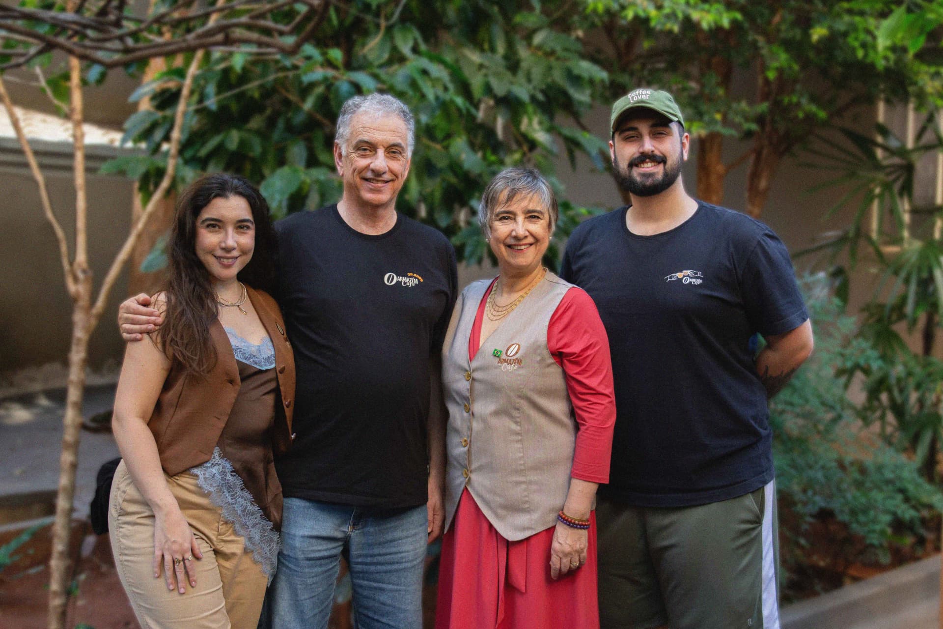 Equipe e família O Armazém Café sorrindo diante dos cafezais