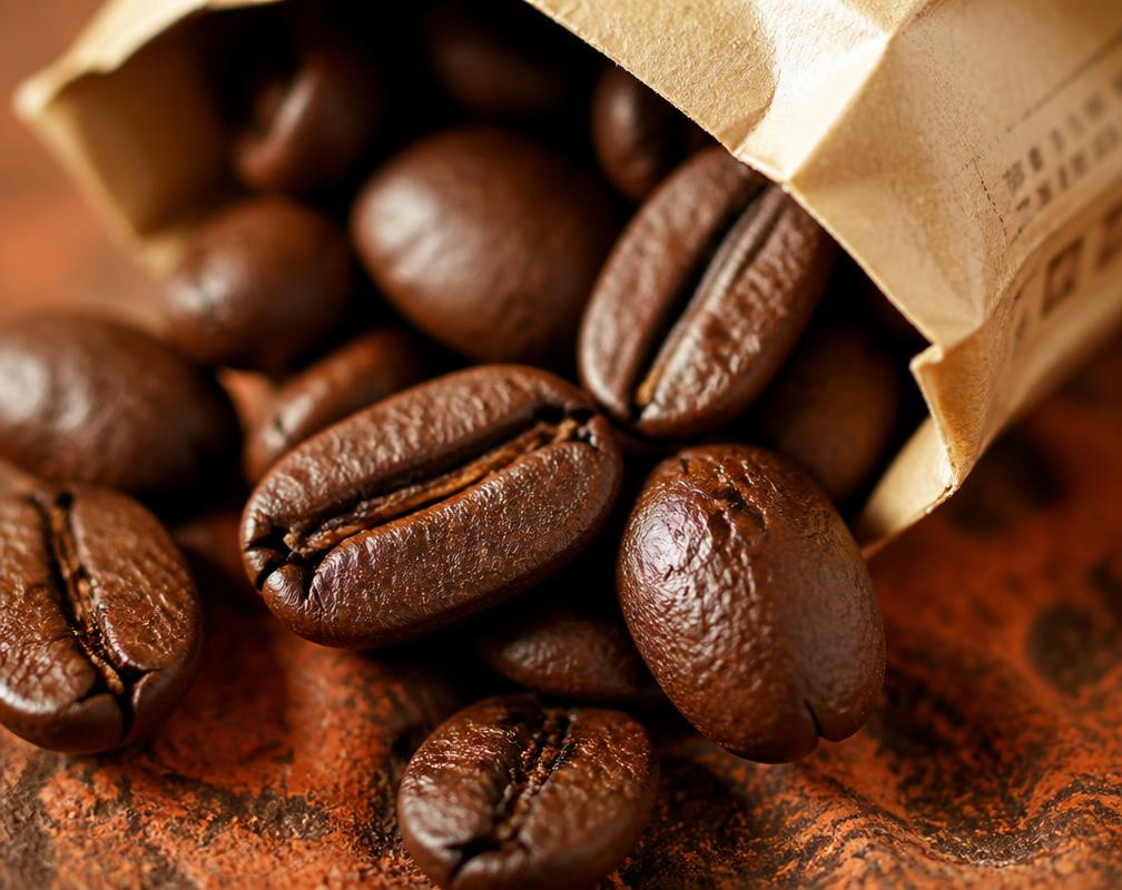 Grãos de café torrados sobre superfície de terra vermelha